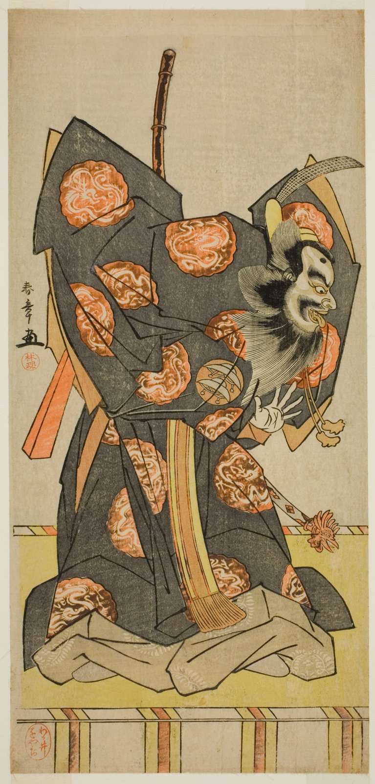 細判の役者絵。鼠色の大紋に橙色の丸紋が十数個散り、その中に白い龍が渦を巻く。座った男は白塗りの顔に真っ黒で太い眉と口髭・顎髭、額に黒い点。頭に黒い冠、顎の下に金色の紐。白い手が指を開く。背後に茶色の棒が立ち、下に灰色の袴が広がる。左上に落款と丸い朱印