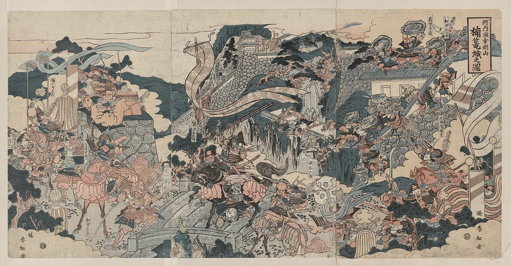 大判三枚続の籠城図。石垣で囲まれた山城に寄せ手が取りつき、騎馬武者が坂を駆け上がる。画面に「金剛山」の文字が読める
