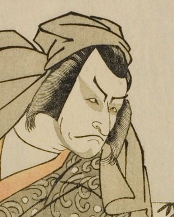 巡礼姿の将門の顔の拡大。白い地肌に、太くまっすぐな眉、上瞼の重い目、下がった口もと。頬から顎に細い線で髭が描かれ、灰色の布が頭を覆っている。顔に色は塗られていない