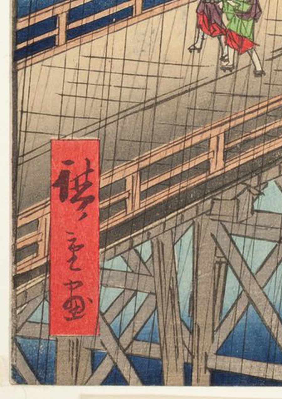 右の一枚の同じ左下隅の拡大。刷り面のすぐ外で紙が断ち切られていて余白がなく、版元印は残っていない。広重の落款は鮮やかな赤